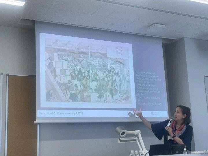 Stephanie Santschi presenting a Hokusai illustrated book on a projected slide